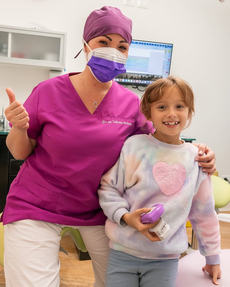 foto-con-bambina-e-dott.ssa-valentino-roberta-post-conegna-apparecchi-intercettiva-superiore-e-inferiore